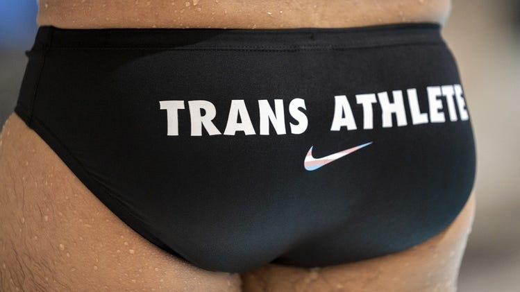 Nov 6, 2023; Boston, MA, USA; Schuyler Bailar poses for a portrait in a suit that reads â€œtrans athleteâ€ at Harvardâ€™s Blodgett Pool. Bailar is an author, educator and swimmer who built a popular social media presence for being outspoken and squashing misinformation about trans people in sports. He swam for the Harvard Men's Swimming and Diving team as the first openly transgender NCAA Division I swimmer.