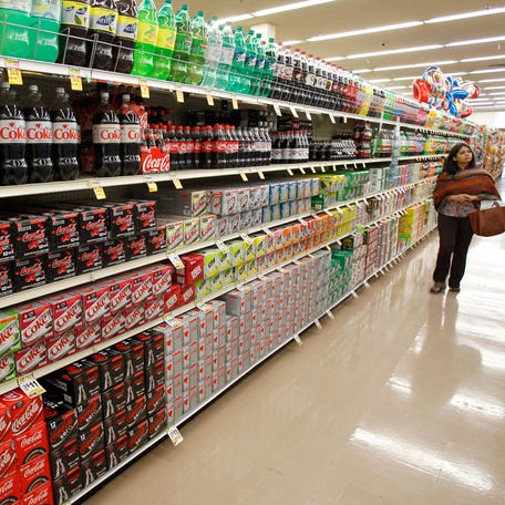 A shopper walks by the sodas aisle at a grocery store in Los Angeles.