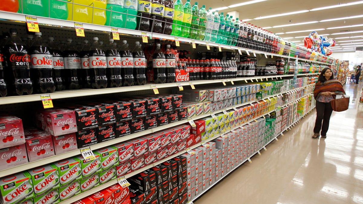 A shopper walks by the sodas aisle at a grocery store in Los Angeles.