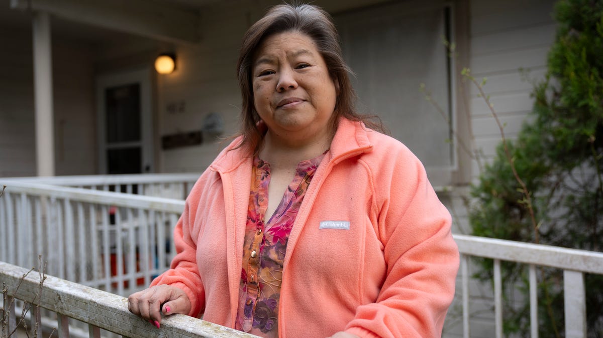 Elizabeth Oshiro stands for a portrait on the porch of the home she inherited from her mother on the day of her eviction after being disenrolled from the Nooksack Tribe in 2016 and fighting to keep her home for all these years.