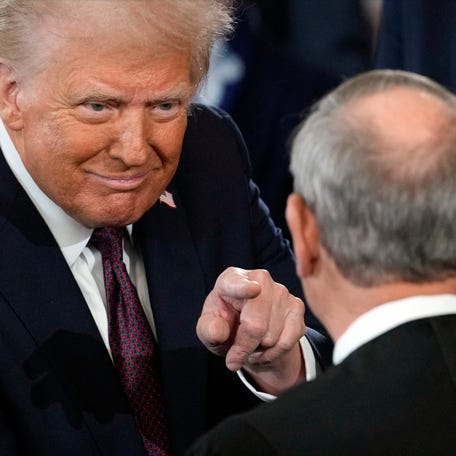 President Donald Trump points to US Supreme Court Chief Justice John Roberts after being sworn in, inside the US Capitol Rotunda in Washington, DC on January 20, 2025.