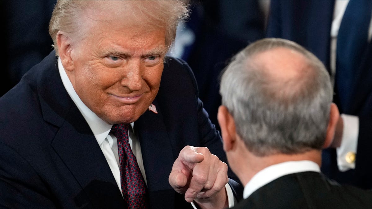 President Donald Trump points to US Supreme Court Chief Justice John Roberts after being sworn in, inside the US Capitol Rotunda in Washington, DC on January 20, 2025.