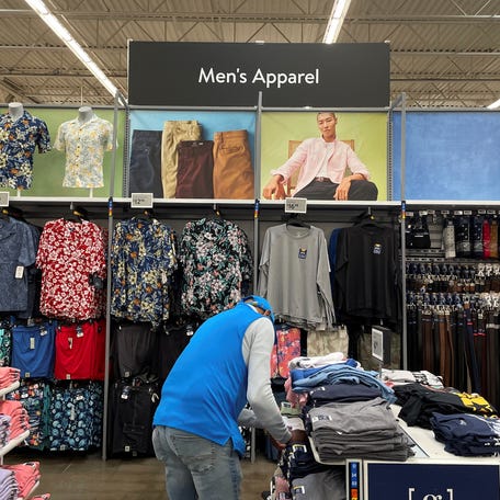 A Walmart employee folds clothes in the men's apparel section at a Walmart Supercenter, a day after U.S. President Donald Trump announced new tariffs, in North Bergen, New Jersey. U.S. April 3, 2025.