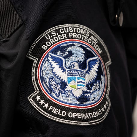 A U.S. Customs and Border Protection seal patch is seen in an Agriculture Specialist uniform as she inspects imported flowers from Ecuador for foreign pests or diseases in the Avianca Cargo warehouse at Miami International Airport in Miami, Florida, on Feb. 7, 2025.