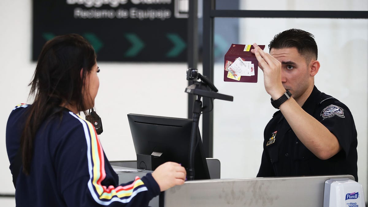 A U.S. Customs and Border Protection officer checking someone's passport in Miami.