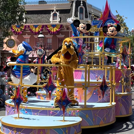 Donald Duck, Pluto, Mickey Mouse and Minnie Mouse make their way down Main Street, U.S.A. during the Celebrate Happy Cavalcade at Disneyland Park.
