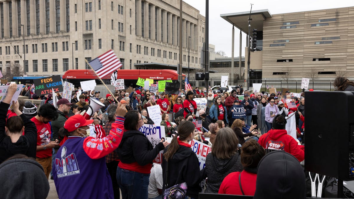 Federal workers and allies hold signs as they listen to a speech during a rally across the street from the Internal Revenue Service (IRS) headquarters, in support of the civil service in the wake of mass firings, and organized by the National Treasury Employees Union (NTEU) in Kansas City, Missouri, U.S. March 15, 2025. REUTERS/Chase Castor