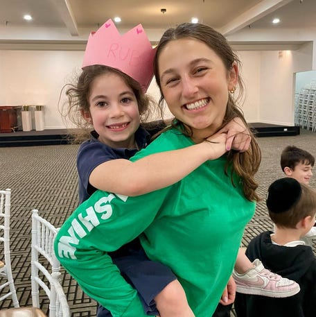 Lielle Blinkoff gives Ruby Kessler a figurative and literal lift at I Shine, an afterschool program for children whose siblings have serious illnesses. The program pairs teen volunteers with "little buddies," helping the children enjoy a sense of normalcy.