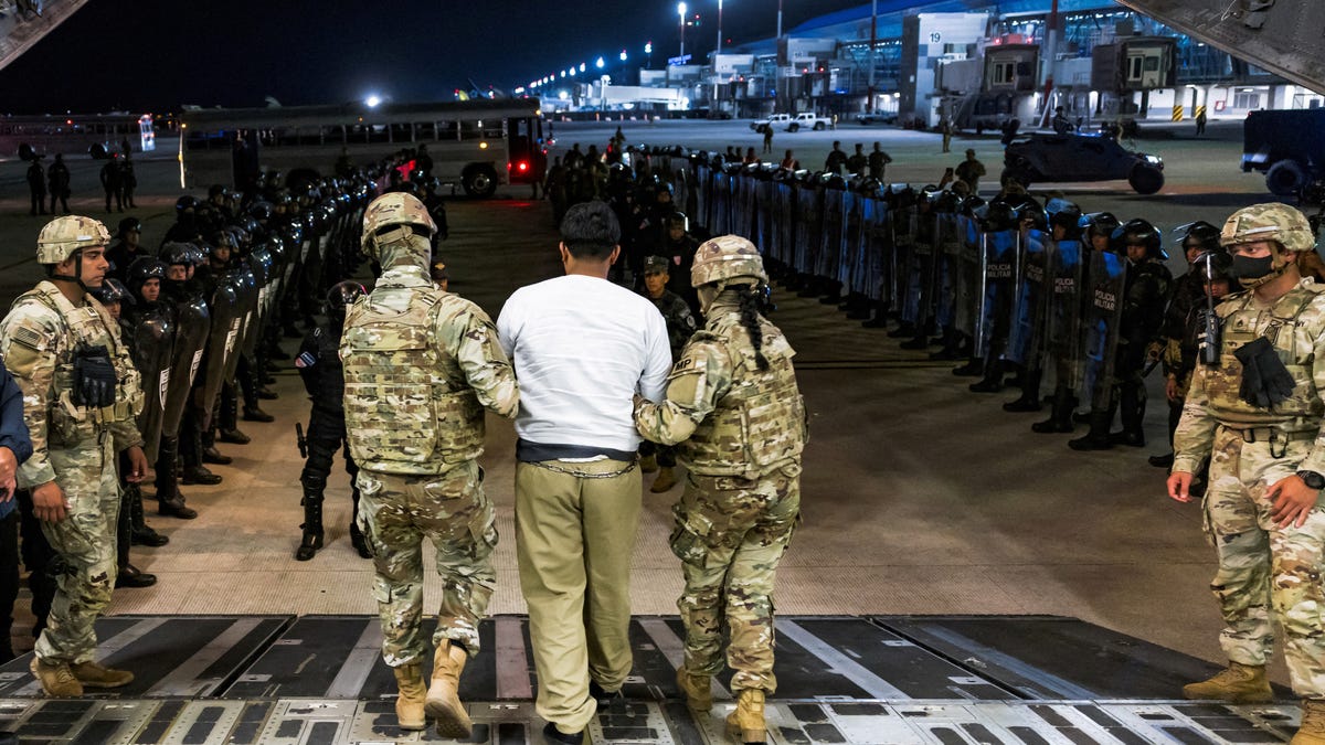 U.S. military personnel escort an alleged gang member who was deported by the U.S. to the Terrorism Confinement Center (CECOT) prison in El Salvador.