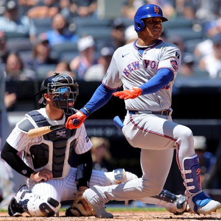 New York Mets right fielder Juan Soto (22) follows through on a single against the New York Yankees during the fourth inning at Yankee Stadium.