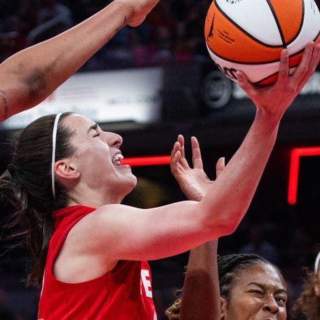 Indiana Fever guard Caitlin Clark (22) shoots the ball while Chicago Sky guard Ariel Atkins (7) defends in the first half at Gainbridge Fieldhouse.