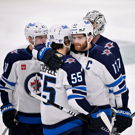 Winnipeg Jets center Adam Lowry (17) hugs center Mark Scheifele (55) after the Jets lose to the Dallas Stars during overtime of Game 6.