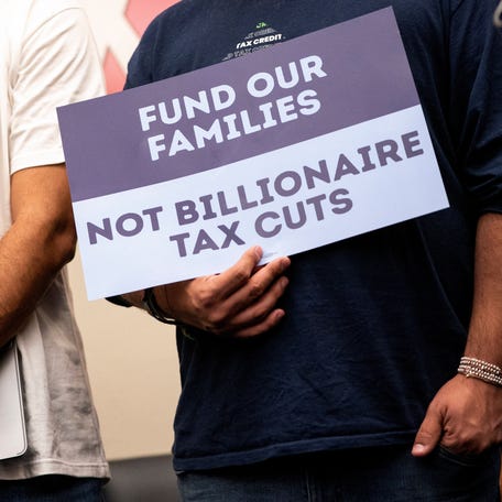 Demonstrators hold signs during a news conference on Capitol Hill in Washington, DC, on May 13, 2025, to discuss cuts to Medicaid, the Supplemental Nutrition Assistance Program (SNAP) and the child tax credit.