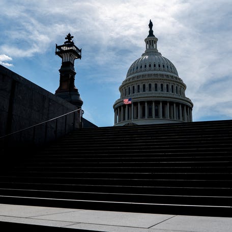 FILE PHOTO: A person walks near the Capitol, as the U.S. House of Representatives considers U.S. President Donald Trump's sweeping tax-cut bill, on Capitol Hill in Washington, D.C., U.S., May 19, 2025. REUTERS/Nathan Howard/File Photo