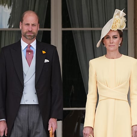 Prince William, Prince of Wales, and Kate, Princess of Wales, stand at the top of the garden steps before the start of the Royal Garden Party at Buckingham Palace in London on May 20, 2025.