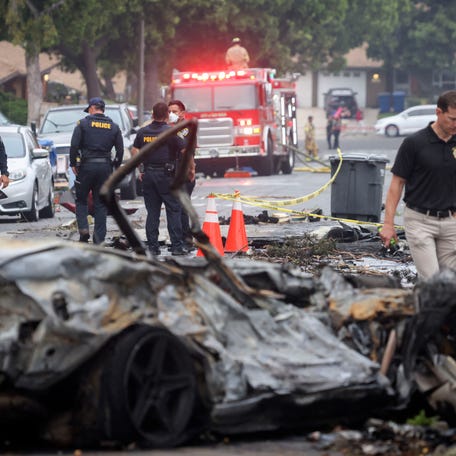 Investigators look through the site where a small plane crashed into San Diego, California, residential street on May 22, 2025.