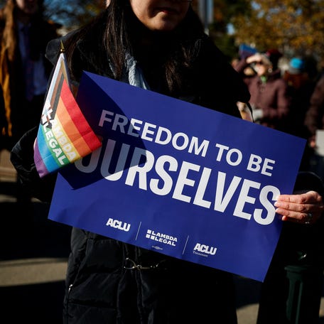 People hold flags and signs as the Supreme Court hears arguments over an appeal by President Joe Biden's administration of a lower court's decision upholding a GOP-backed ban in Tennessee on gender-affirming medical care for transgender minors in Washington on Dec. 4.