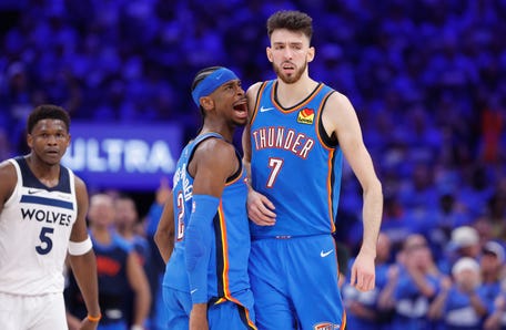 Oklahoma City Thunder guard Shai Gilgeous-Alexander (2) and forward Chet Holmgren (7) celebrate after a play against the Minnesota Timberwolves.