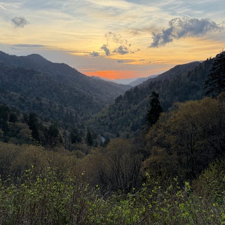 The sun sets on America's most visited national park, Great Smoky Mountains. Many travelers are considering domestic vacations this summer to save money.