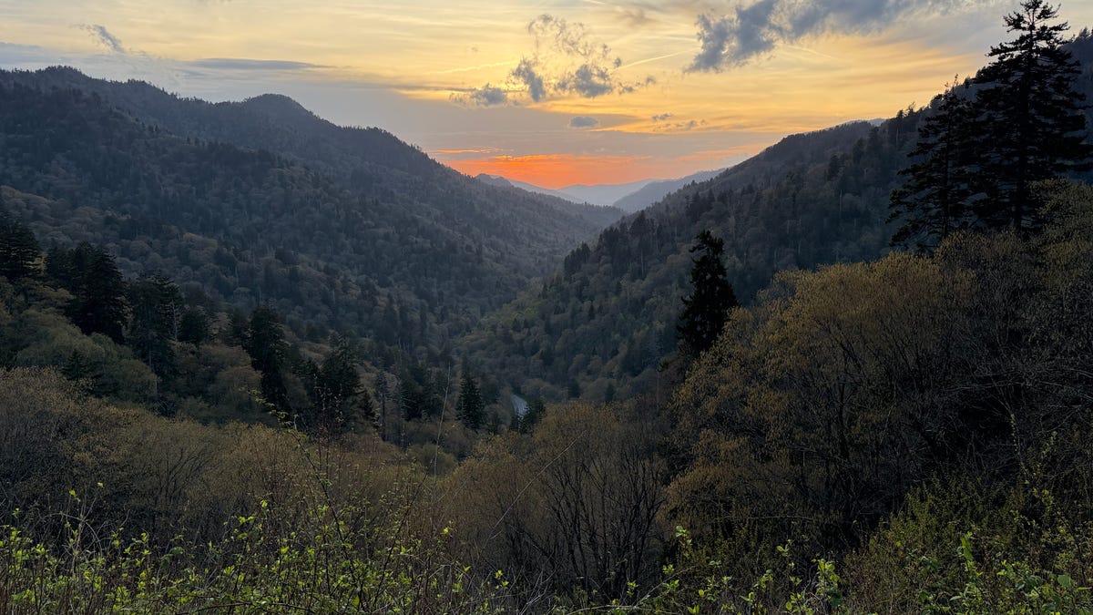 The sun sets on America's most visited national park, Great Smoky Mountains. Many travelers are considering domestic vacations this summer to save money.