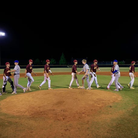 The Fernandina Beach Pirates, gray uniforms, show sportsmanship with the West Nassau Warriors after a school baseball game in the Region 1-3A playoff matchup on April 24, 2025.