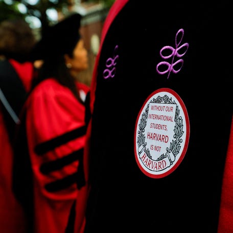 An attendee wears a sticker that reads "Without our international students, Harvard is not Harvard" during the 374th Commencement exercises at Harvard University in Cambridge, Massachusetts, U.S., May 29, 2025. REUTERS/Brian Snyder