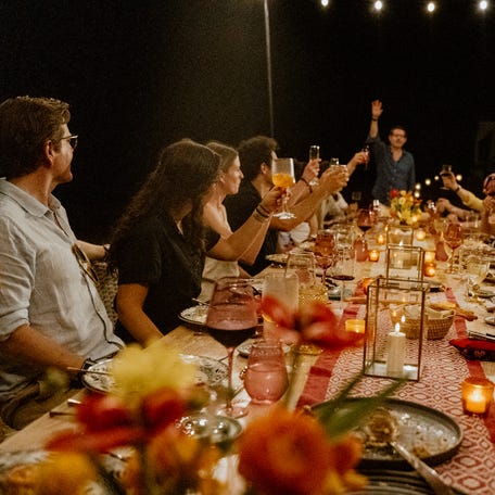 Guests of the Mexico resort Naviva, raise their glasses to toast the Naviva Unplugged experience after Nashville artist Marc Scibilia played on the beach, followed by a family style dinner.