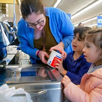 Molly Reid shops for groceries Thursday, Feb. 16, 2023, with her children, Oliver and Skye, in Oklahoma City.