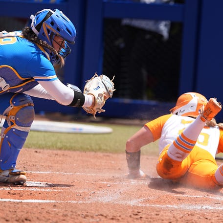 Tennessee's McKenna Gibson (24) slides into home for a score as UCLA's Alexis Ramirez (28) tries to place the tag in the first inning of the Women's College World Series softball game between the UCLA Bruins and the Tennessee Volunteers at Devon Park in Oklahoma City, Sunday, June, 1, 2025.