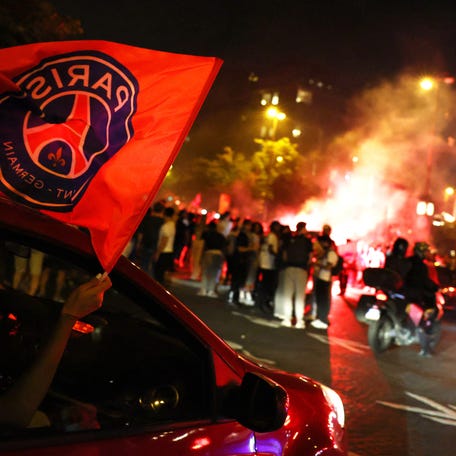 A fire burns as Paris Saint-Germain fans celebrate in Paris after the team won the Champions League.
