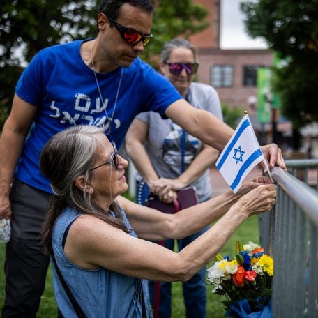 Lisa Turnquist of Louisville, Colorado, lays flowers and a flag at the site of the attack outside the Boulder County Courthouse on June 2, 2025 in Boulder, Colorado. The suspect, an Egyptian citizen who had overstayed his visa, has been charged with a hate crime by the FBI.