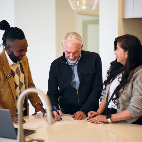 A professional real estate agent, showing a new home to prospective buyers.