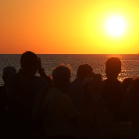 People snap photos at sunset in Key West, Florida, in this file photo from Feb. 5, 2017.