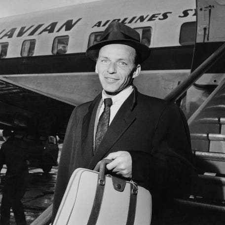 Frank Sinatra (1915 - 1998), American singer and film star, arriving at an airport on April 13, 1956. (Photo by Hulton Archive/Getty Images)