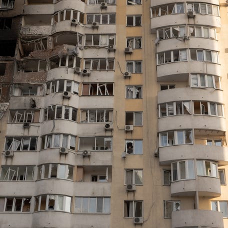 A person looks out from a broken window in a residential building damaged during a Russian air strike in Kyiv on June 6, 2025, amid the Russian invasion of Ukraine.