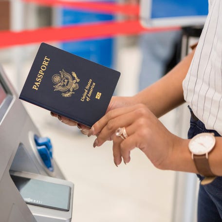 Unrecognizable business traveler uses an automated passport control kiosk at an international airport.