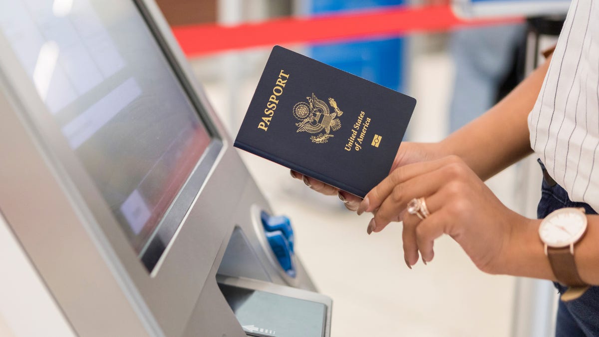 Unrecognizable business traveler uses an automated passport control kiosk at an international airport.