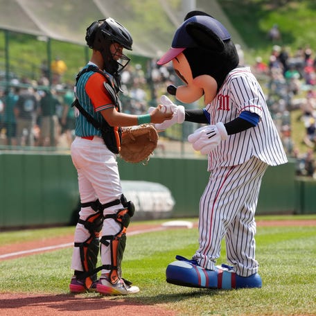 Jesus Diaz, with the Latin America Region team from Barquisimeto, Venezuela meets with Mickey Mouse after throwing a ceremonial first pitch before the International Championship game during the Little League World Series in South Williamsport, Pennsylvania on Aug. 24, 2024.