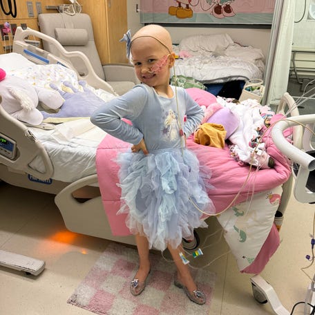 Charlie poses at Seattle Children's Hospital in her Disneyland themed hospital room while getting chemotherapy.