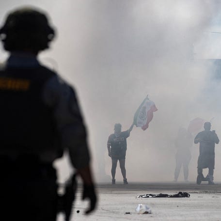 Protesters in Compton, a city in Los Angeles County are blanketed in smoke June 7 during a standoff with law enforcement following multiple detentions by Immigration and Customs Enforcement.
