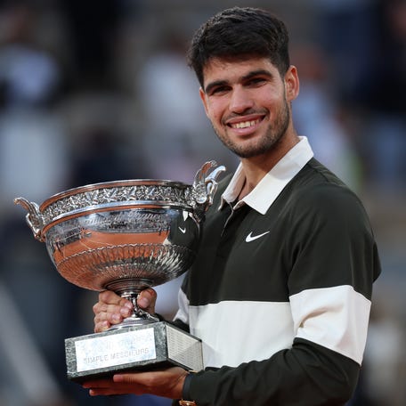 Carlos Alcaraz of Spain holds the Coupe des Mousquetaires trophy following his victory over Jannik Sinner of Italy in the 2025 French Open men's final.