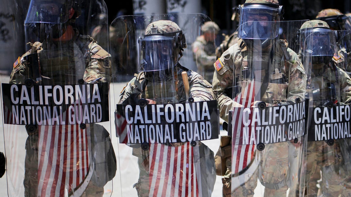 Members of the California National Guard carry shields during a protest against federal immigration sweeps in downtown Los Angeles, California on June 8, 2025.