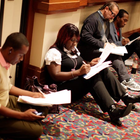 People fill up job application forms at a job fair in Los Angeles, California.