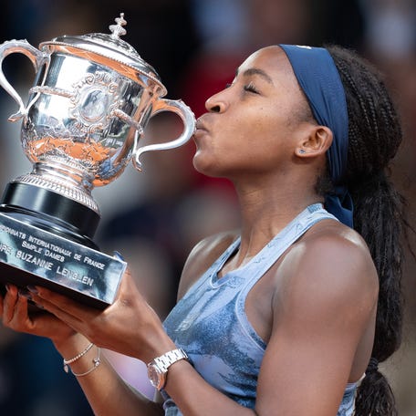 Coco Gauff of the United States kisses the trophy after winning the women's singles final against Aryna Sabalenka on day 14 at Roland Garros Stadium.