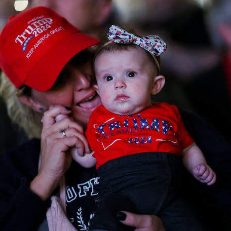 A woman holding a baby reacts in the audience as former U.S. President and Republican presidential candidate Donald Trump attends the National Rifle Association (NRA) Presidential Forum at the Pennsylvania Farm Show Complex & Expo Center, in Harrisburg, Pennsylvania, U.S., February 9, 2024.