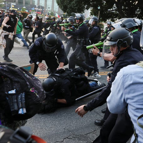 Police officers detain a demonstrator during protests against federal immigration sweeps in Los Angeles on June 9, 2025.