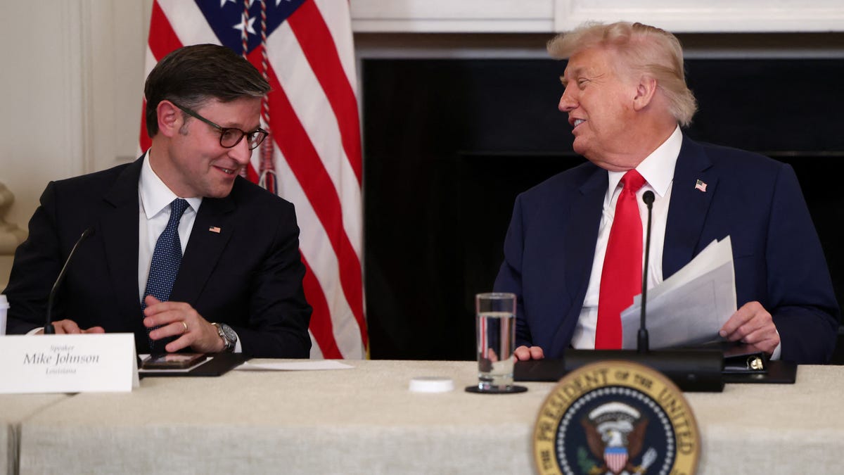 U.S. President Donald Trump and U.S. House Speaker Mike Johnson react during an Invest America Roundtable in the State Dining room, at the White House, in Washington, U.S., June 9, 2025.