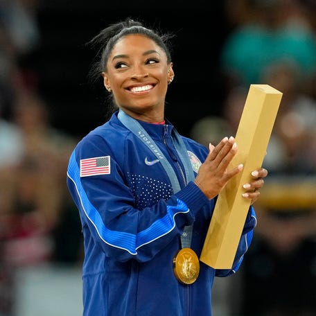 Simone Biles of the United States during the national anthem with her gold medal during the medal ceremony for the vault on the first day of gymnastics event finals during the Paris 2024 Olympic Summer Games.