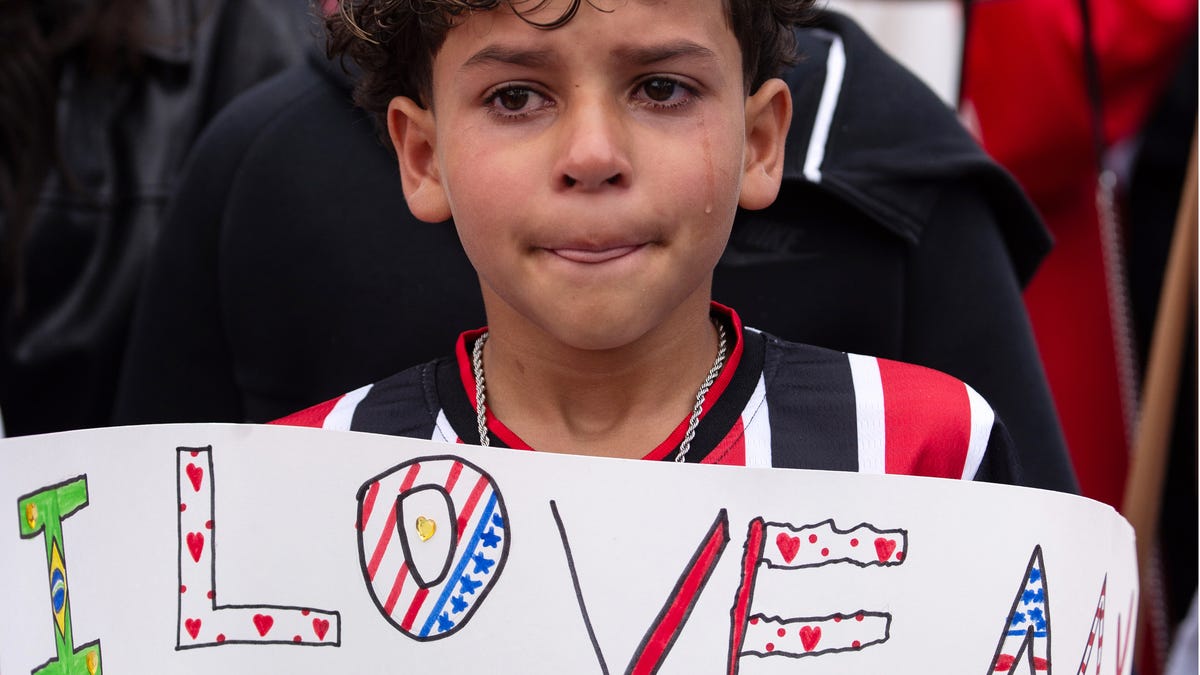 The 11-year-old cousin of a Milford High junior who was detained by ICE on Saturday, stands with a sign during a protest in front of Milford Town Hall on Main Street, June 1, 2025.