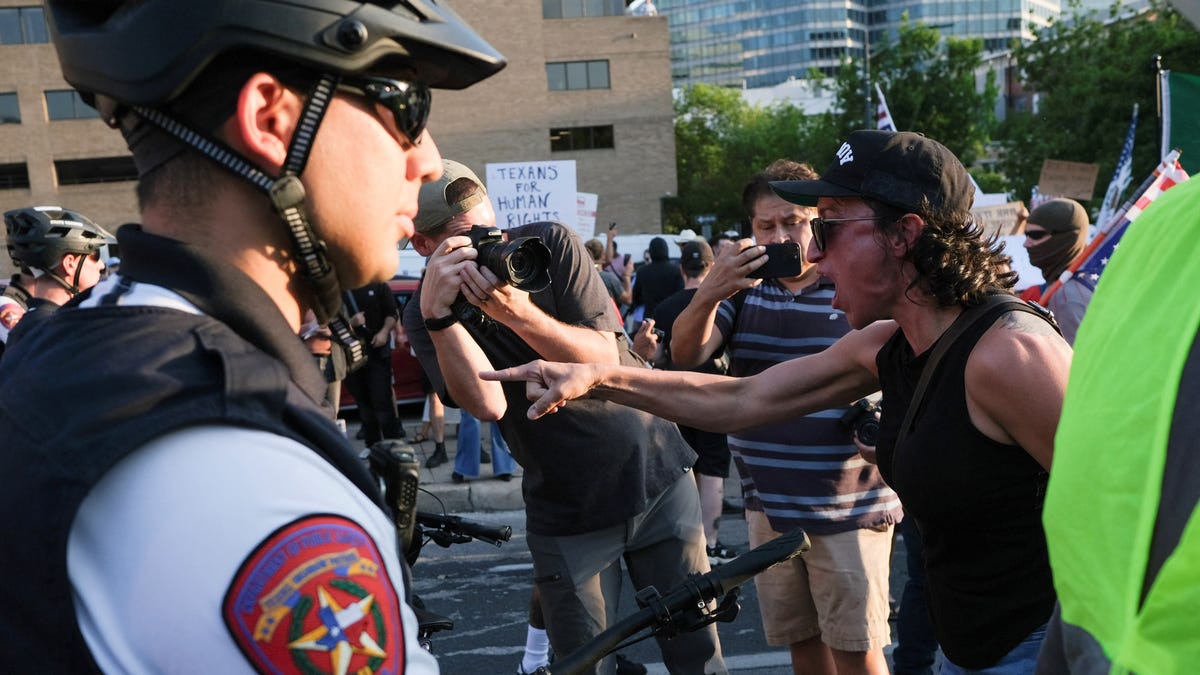 A demonstrator gestures at law enforcement officers during a rally in solidarity with Los Angeles protests against federal immigration sweeps in Austin, Texas, on June 9, 2025.